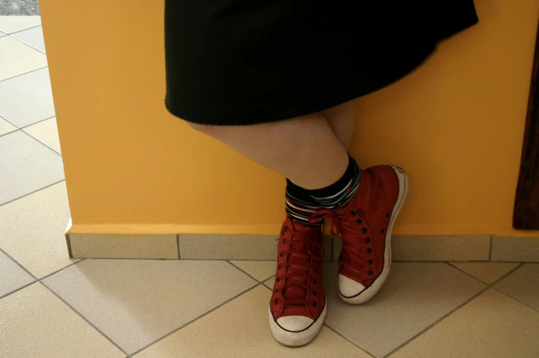 a person standing on a wall with red shoes