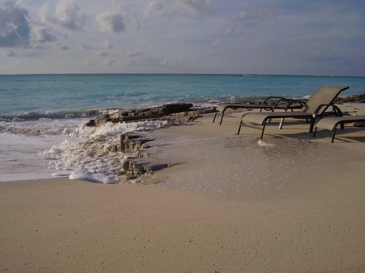 a beach with several lawn chairs on it