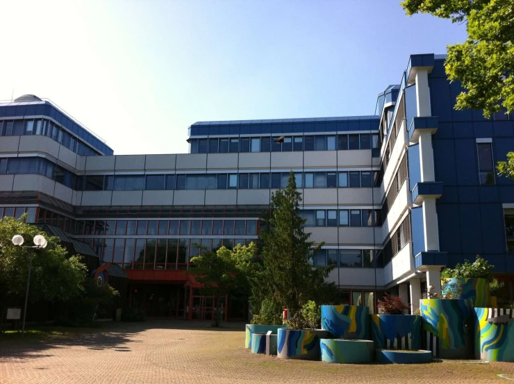 a building is shown behind several colorful planters