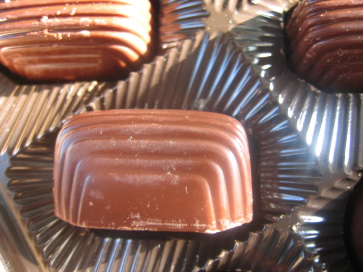 chocolates in aluminum pan with brown frosting sitting on top of each