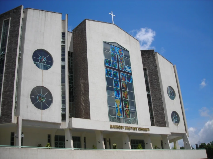 a church with a cross on top and stained glass windows