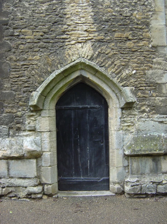 an old church's black door has been decorated with brick