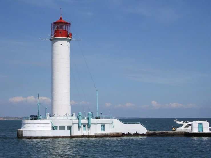 a large white and red lighthouse on top of water