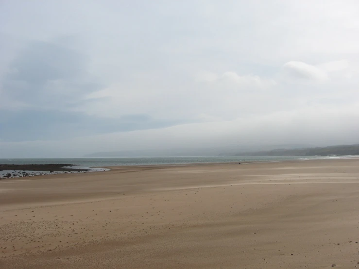 two people walking on the sand at the beach