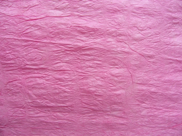 a piece of pink colored paper that has been crumbled