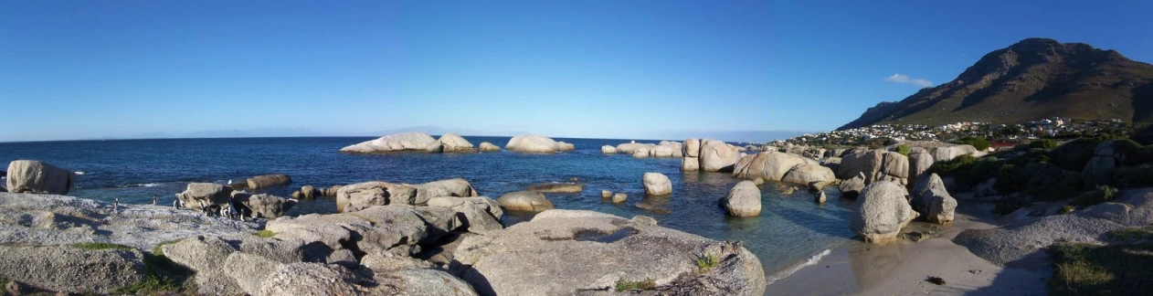 a large rock outcropping next to a shore line