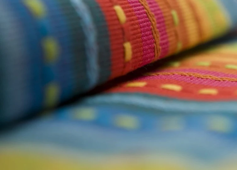 a multicolored fabric is laying on a bed