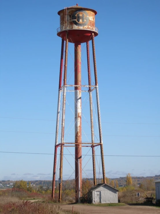 an old water tower sits near a farm