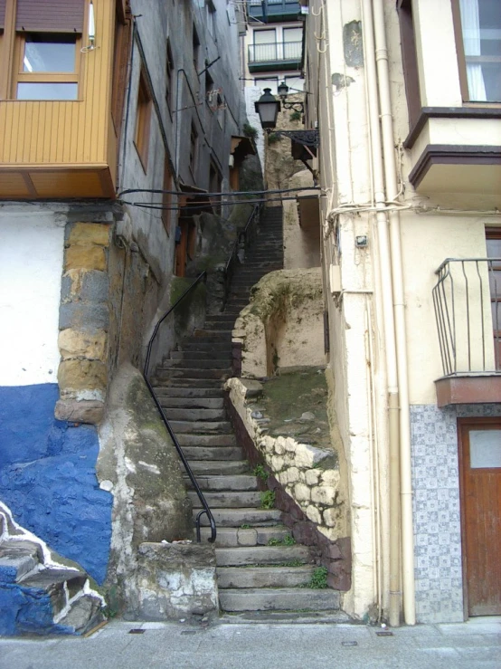 an alleyway leading to apartment buildings with steps