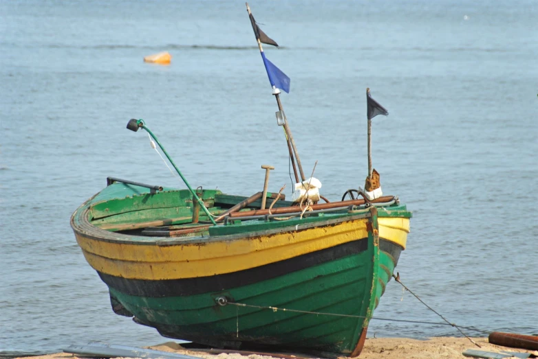 an old boat is parked on the beach near the water