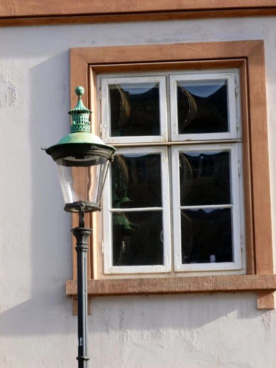 there is a lamp outside the window and it has green decoration