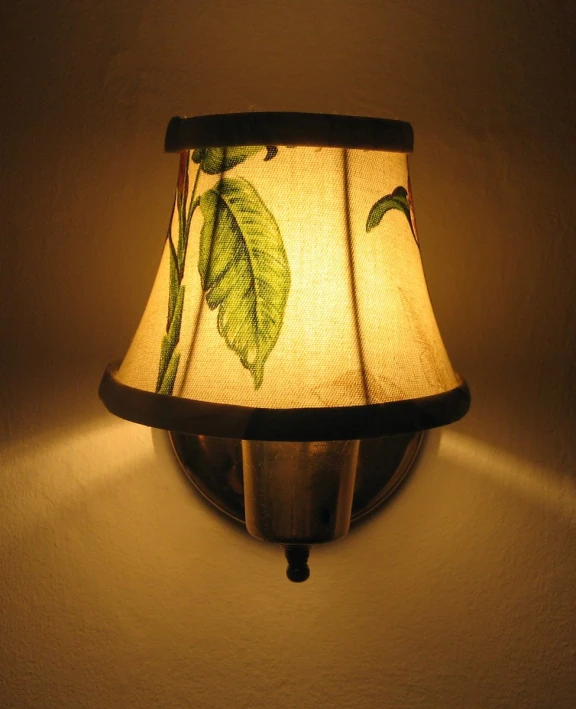 lamp shade featuring leaf motif on wall mounted on white painted walls