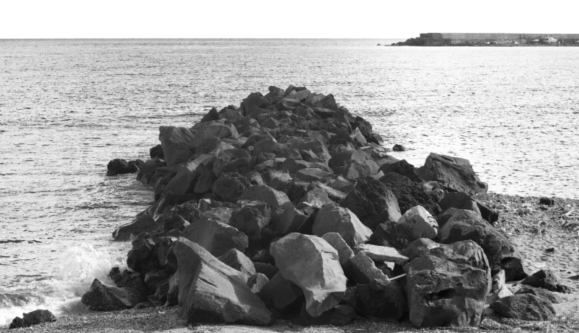 a large rock sticking out of the water on the shore