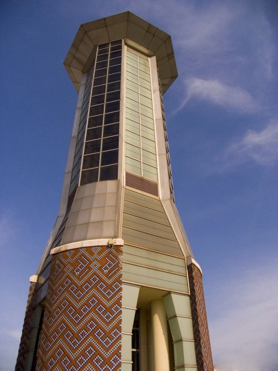 a white and orange tower next to the sky