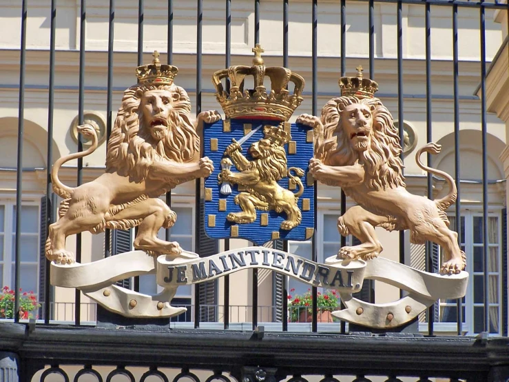 a gate with two lions and three royal crests on top