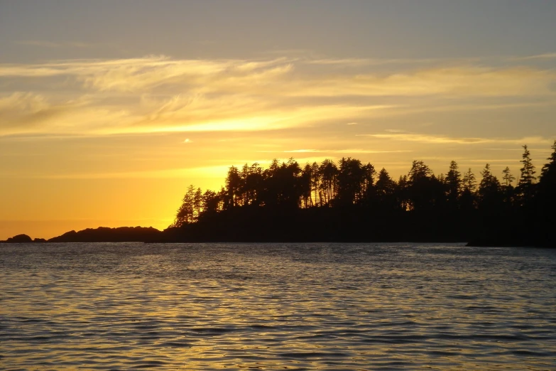 the sunset reflecting on the water by some small island