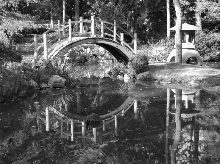 an old japanese styled garden with a bridge