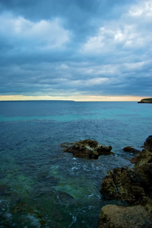 water on the shore is almost calm, with dark clouds