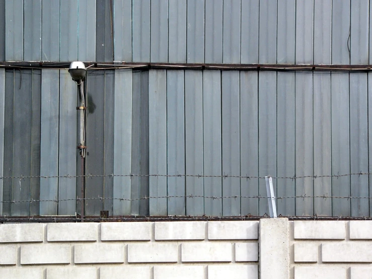 a chain linked metal fence with two street signs