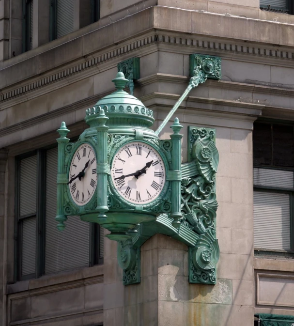 green decorative clock attached to the side of an old building