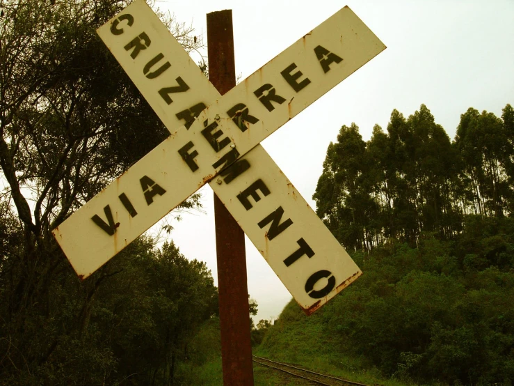 an old railroad sign that is on top of a post