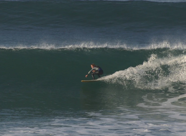 a surfer on the side of a large wave on a surf board