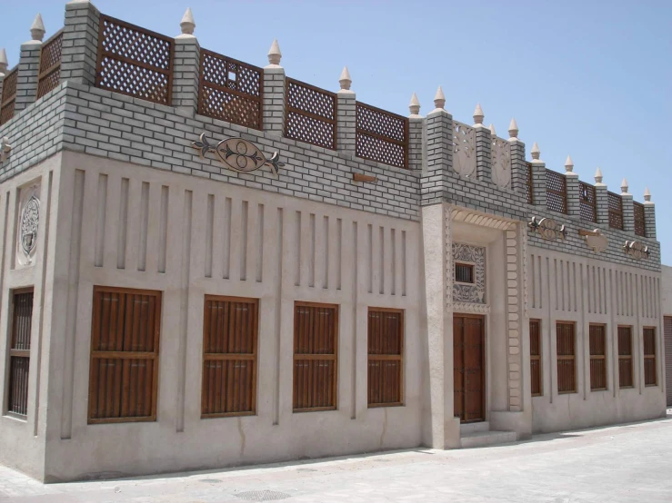 the corner of a building has windows with small wooden doors