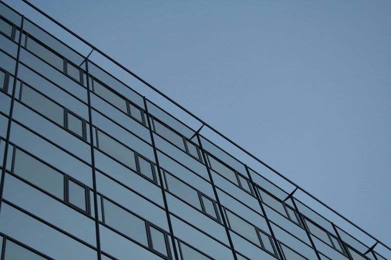 an airplane flying past a tall building that is made from windows