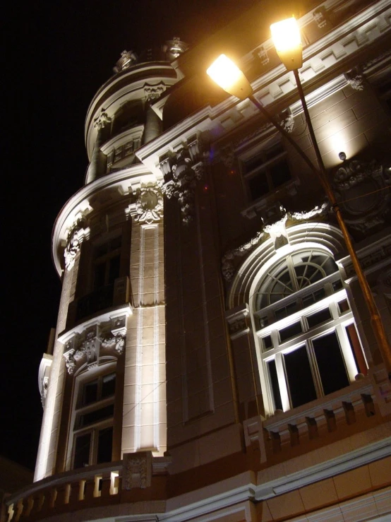 two lamp post on the side of a building at night