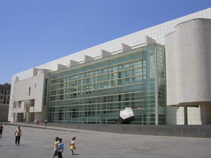 the exterior of a building with a few children walking past