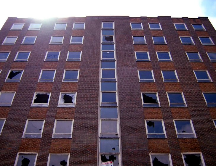 the windows of an empty building have shattered and broken glass