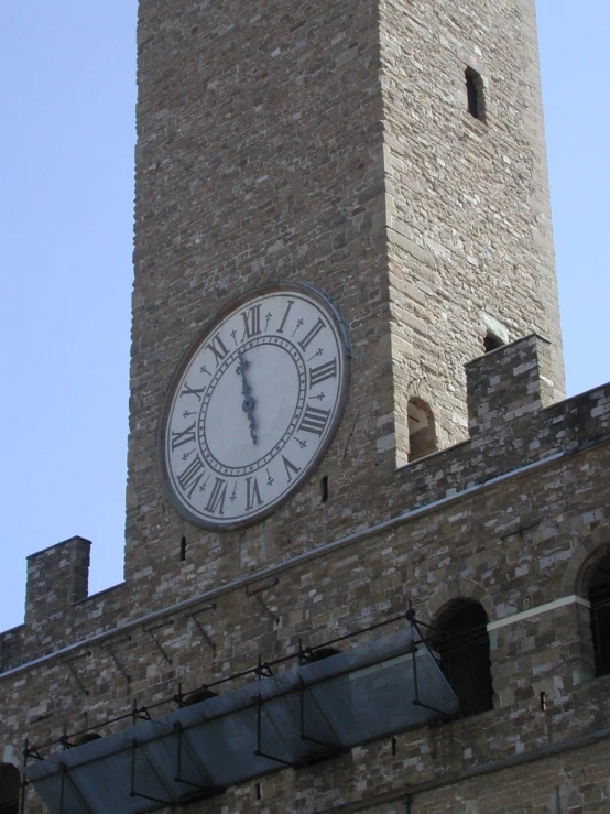 there is a clock on the side of a tall brick building