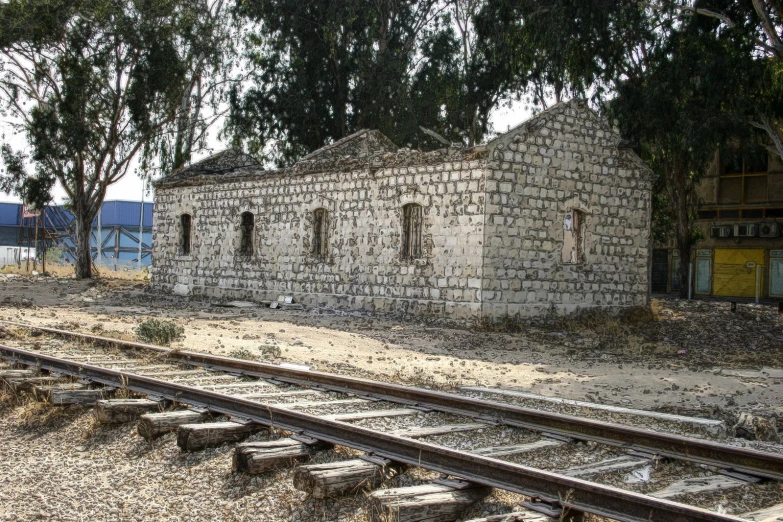 a very old brick building sitting on top of railroad tracks