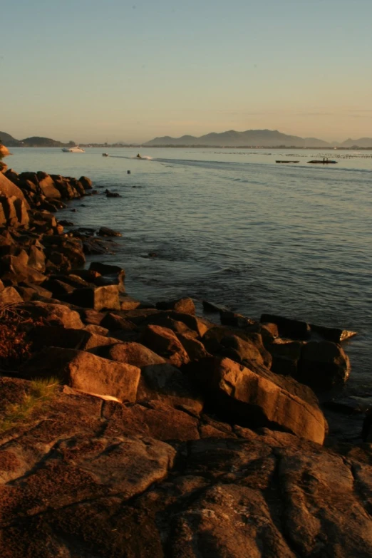 people are out on the water near a rocky shore