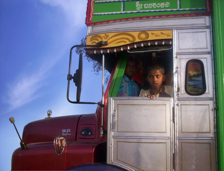 the boy is sticking his head out of the open car door