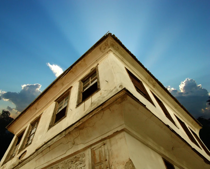 an old building under the sunlight and some clouds