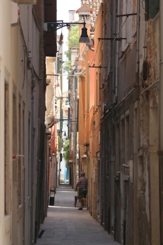 a narrow street that has an alley way leading to some buildings