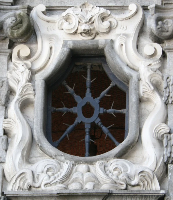 a clock is pictured behind an architectural carving