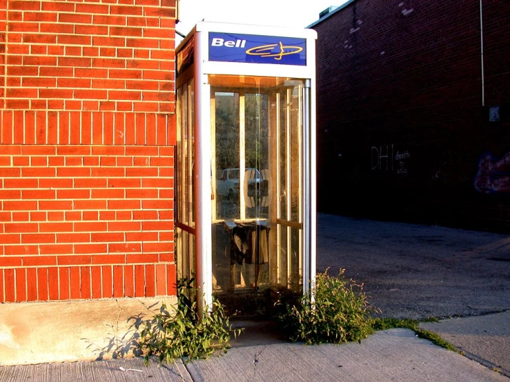 the store phone is on display outside near a red brick building