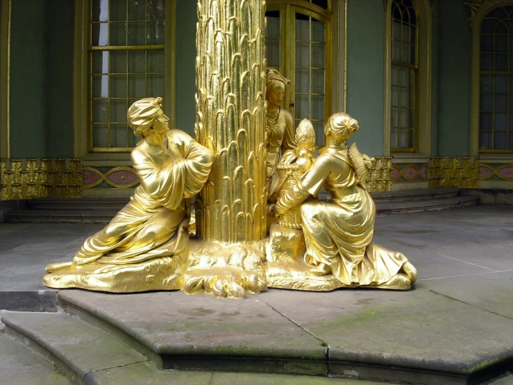 an elaborate golden sculpture is sitting on the ground