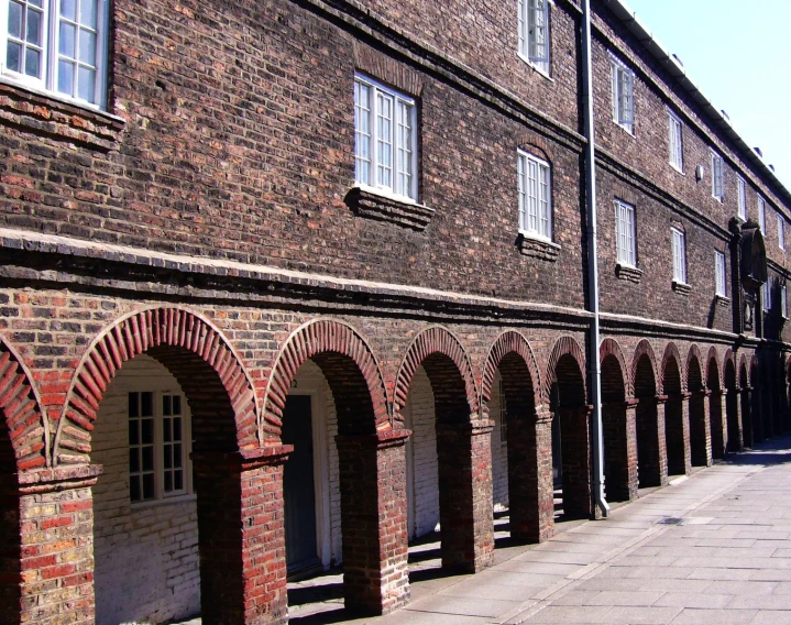 a large brick building has rows of arched brick pillars