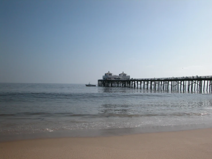 there is a boat going by a pier that goes over the ocean