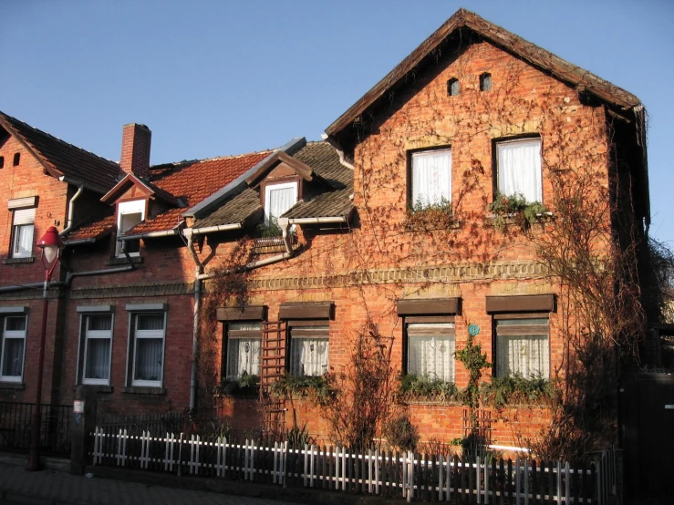 a home made of brick with a white fence