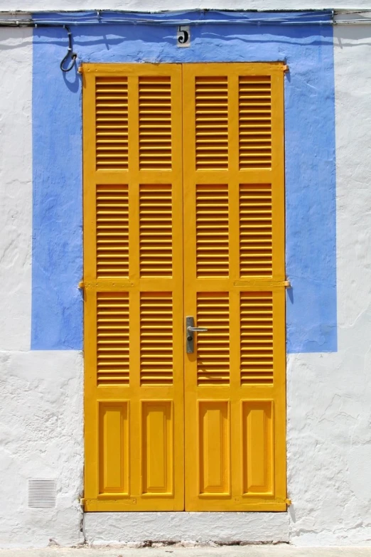 a stop sign sitting next to a yellow door