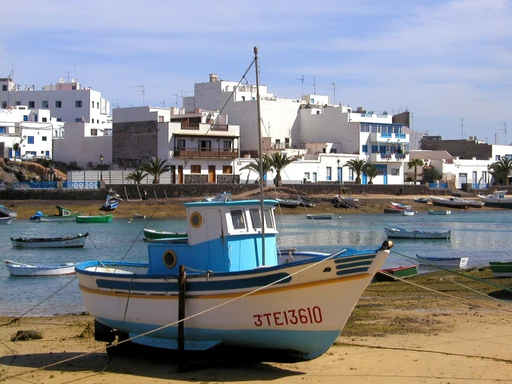 a fishing boat rests on the beach beside the coastline