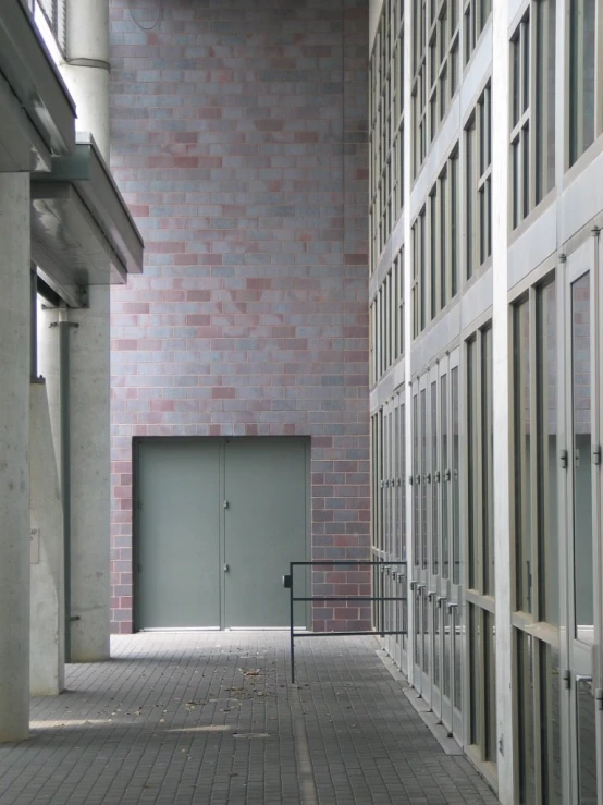 a narrow corridor with large windows and a door