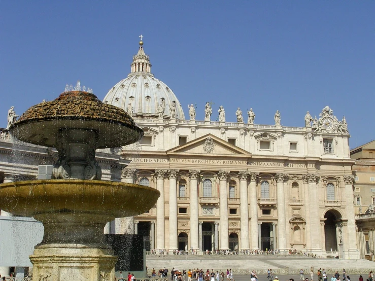 a large white building is next to a fountain