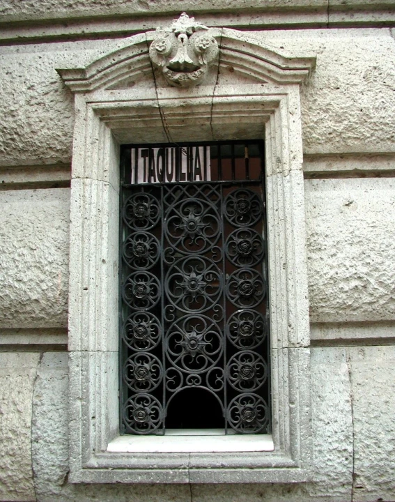 a building has a window with ornate iron work