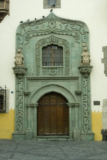 two brown doors are in front of a green facade