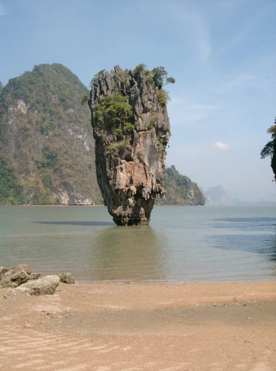 a large rock sticking out of the water at the beach